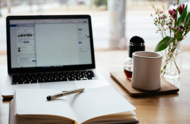 Laptop, schrijfboek en koffie