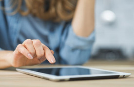 Een vrouw wijst met haar hand iets aan op een tablet