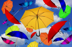 gekleurde paraplu's zwevend in de lucht met wolken