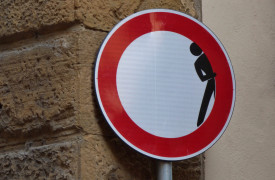een verbodsbord waarin een poppetjes om het hoekje kijkt