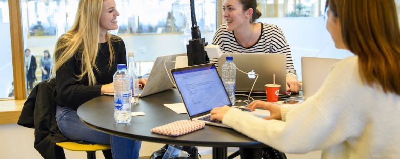 Drie studentes aan een tafel