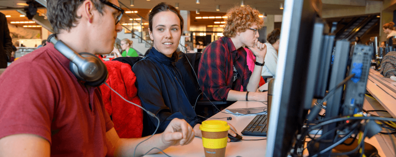 Studenten praten achter pc
