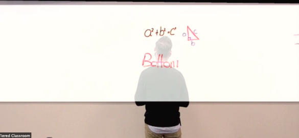docent voor een whiteboard. je ziet de tekst door de docent heen.