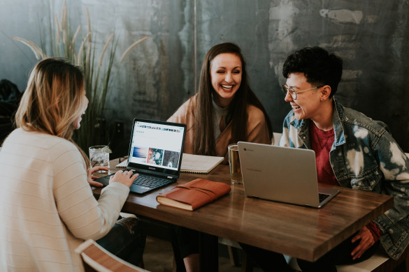 drie studenten aan tafel met een laptop