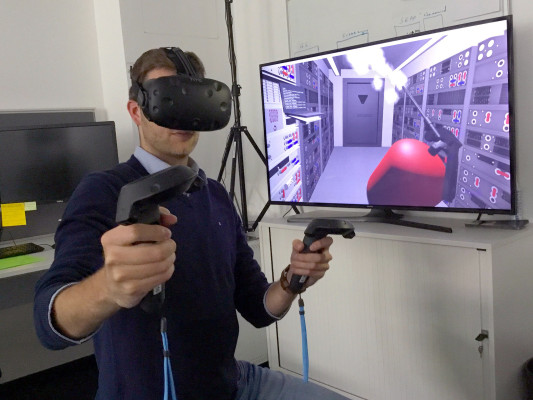 Researcher with the European Space Agency in Darmstadt, Germany, equipped with a VR headset and motion controllers (Credit: ESA)