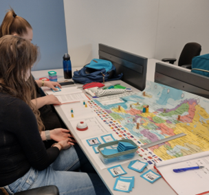 jongeren spelen spel met kaart van Europa, pionnen, een timer een instructiekaartjes