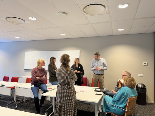 A group of seven people brainstorming around table