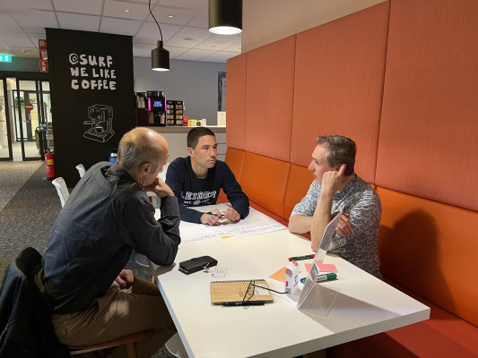 Three people brainstorming around a table