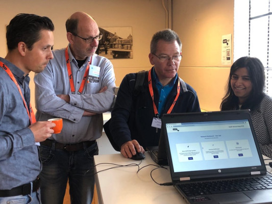 Foto van mensen rondom een laptop