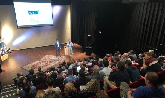 Foto van een presentatie met publiek