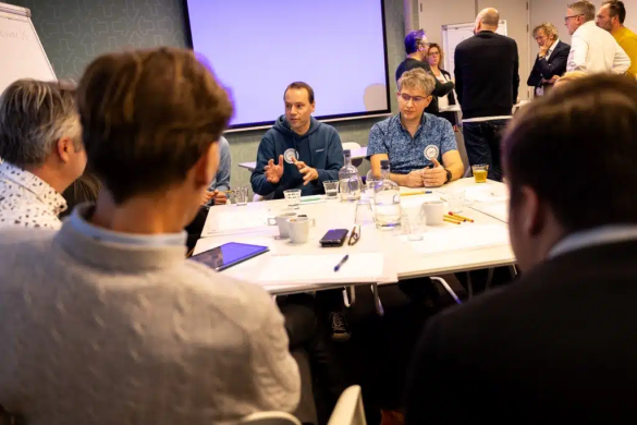 Mensen zitten rond een tafel en bediscussiëren uitdagingen rondom XR in het onderwijs.