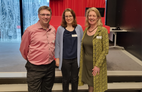 Freek Dijkstra, Dorien Huijser and Annette Langedijk standing in the Boothzaal at the Utrecht University Library, smiling into the camera.