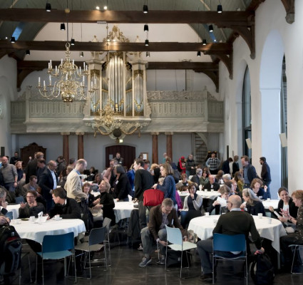 Foto van de zaal met publiek