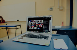 een tafel met een laptop met daarop een videocall