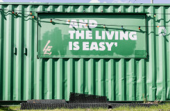een groene zeecontainer met daarop de tekst: and the living is easy