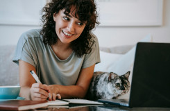 vrouw en kat achter laptop