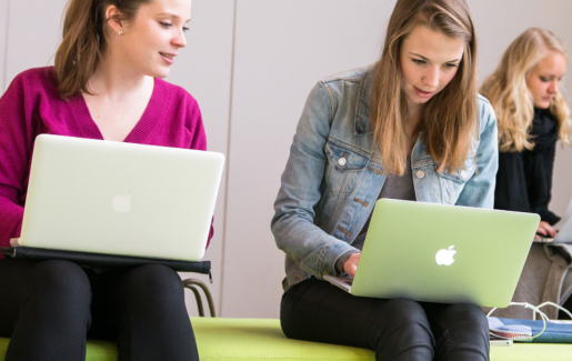 Studenten achter laptop op loungebankjes